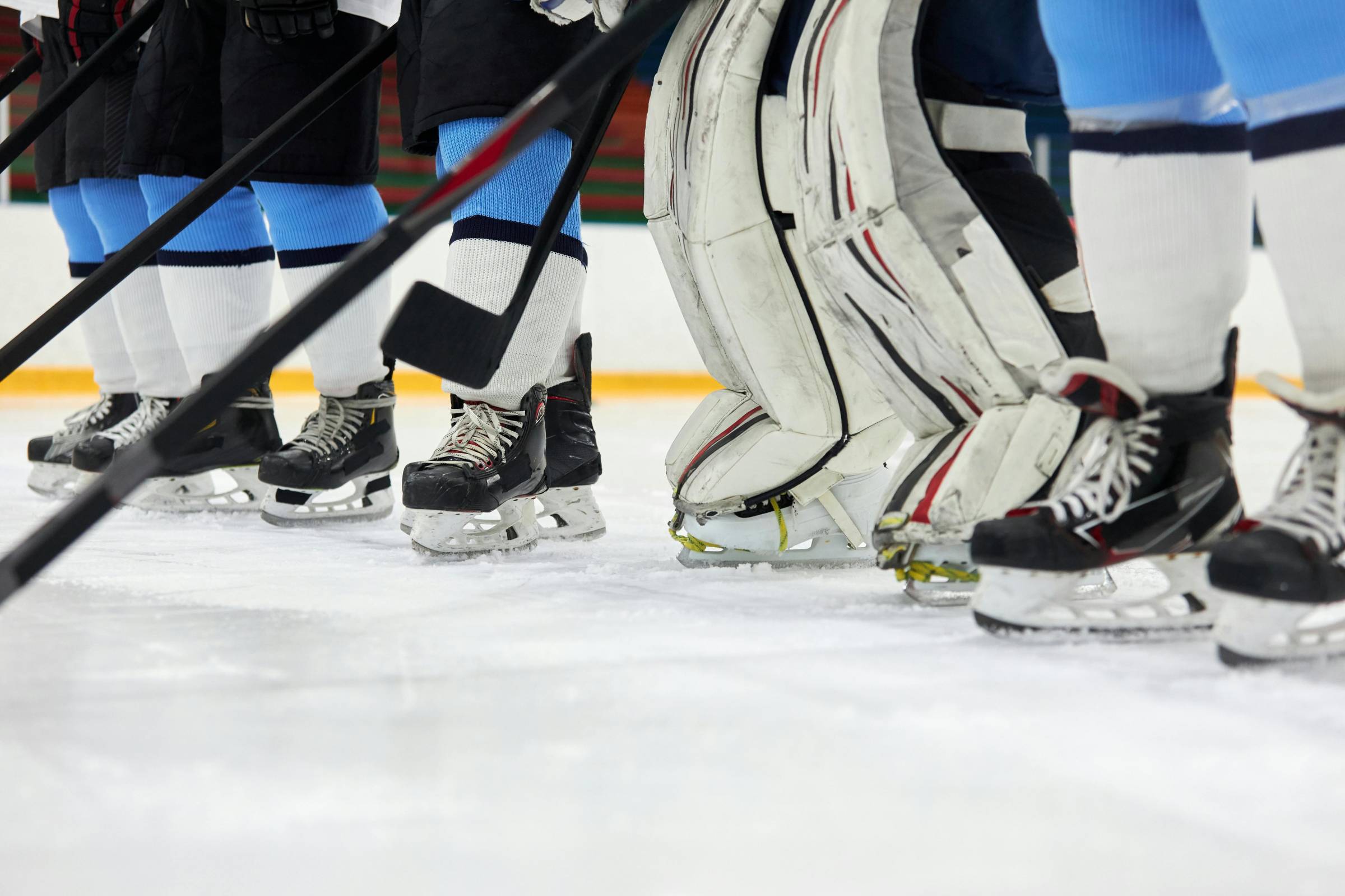 Hockey players skates and sticks on ice. Photo by Tony Schnagl