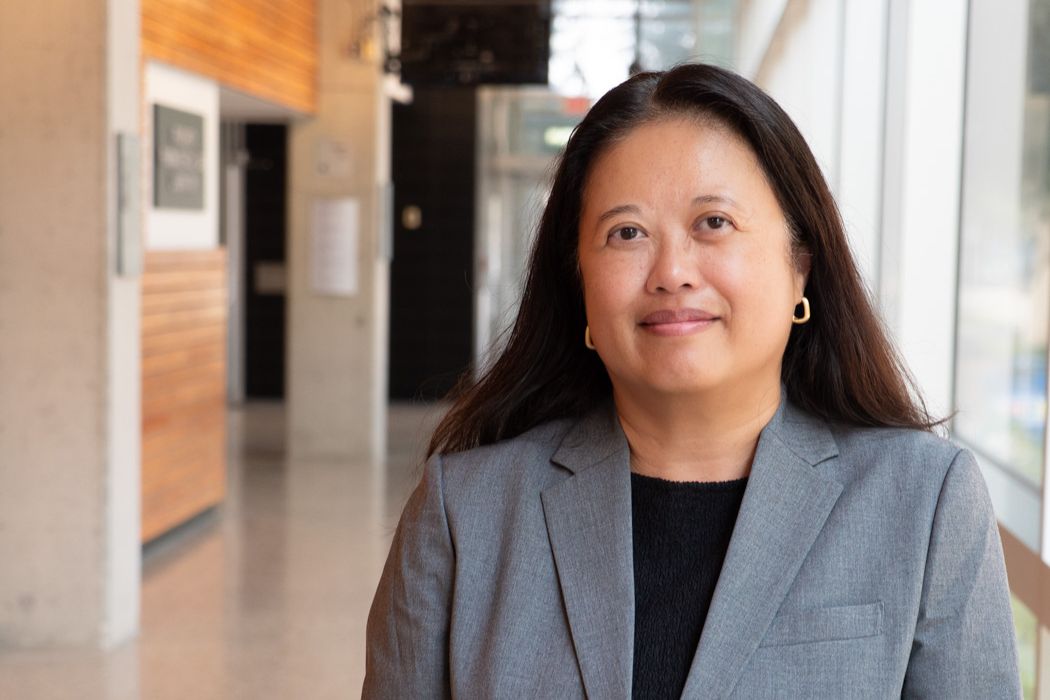 Dr. Hope Anderson, in a hallway, smiles at the camera.