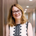 Dr. Sarah Forgie stands in a hallway.