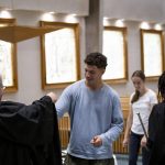 student member putting on their robe after signing the matricula