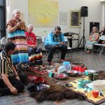 A group of Indigenous leaders around items for a water and pipe ceremony on Bannatyne campus.