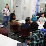 Library staff speaking to a group of students in the library