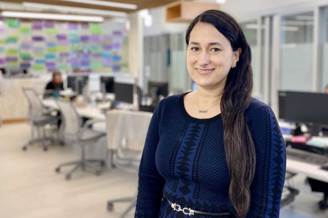 Portrait of Oksana Harasemiw in a room with many computers on desks.