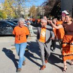 People with orange shirts walk through the University Manitoba Fort Garry campus.