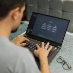Person sitting at desk with laptop open to ChatGPT homepage.