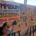 A visual recording of the first day of the Ruby Sachs Symposium stretched out on three easels in a lobby in front of windows.