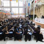 Graduands seated for convocation at Bannatyne campus. University of Manitoba president Michael Benarroch addresses them from the stage.
