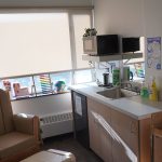 A room with a sink, mini fridge, microwave, change table and large comfortable table with a stool. Toys, posters, resource material and cleaning supplies are also available in this lockable space for child feeding on the UM Fort Garry Campus.