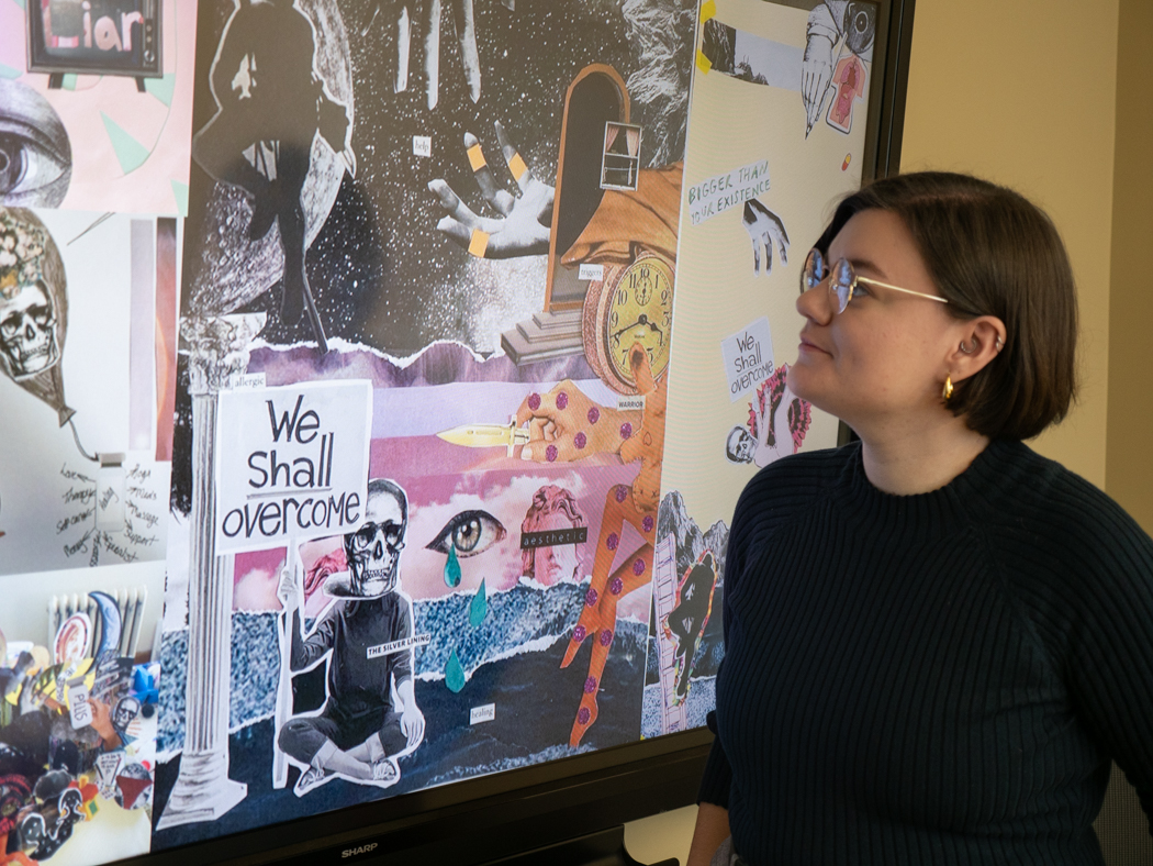 Jen Sebring looks at a digital display showing a collage of participant-created artwork.