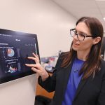 Dr. Britt Drogemoller points to a screen showing spatial maps of gene expression in a mouse brain.