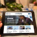 Hand holding a tablet displaying the University of Manitoba’s UM Today news site, featuring a story titled “The comeback crop."