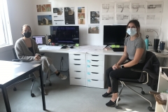 Brooke and Carmen sit together at their desks in the Holz Construction office.